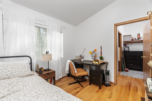 bedroom featuring hardwood / wood-style floors, a closet, and vaulted ceiling