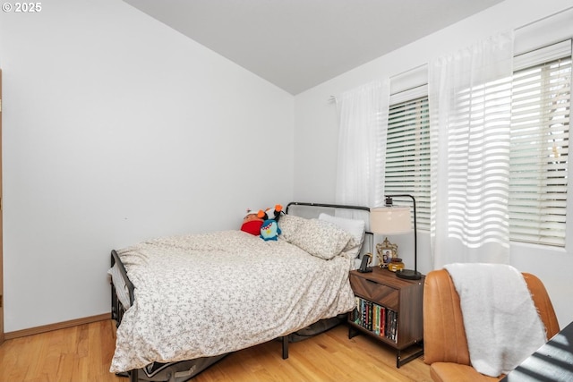 bedroom with hardwood / wood-style flooring and vaulted ceiling