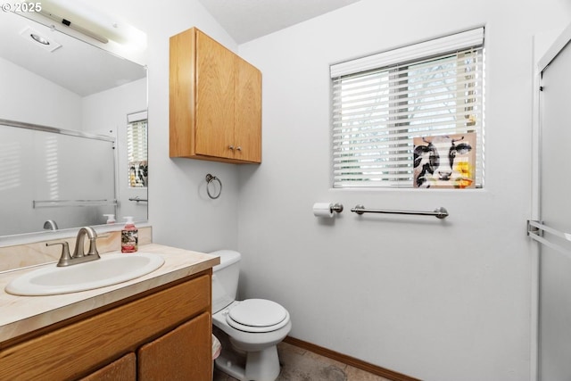 bathroom with vanity, a shower with shower door, and toilet