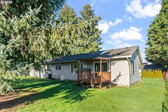 back of property with a lawn and a wooden deck