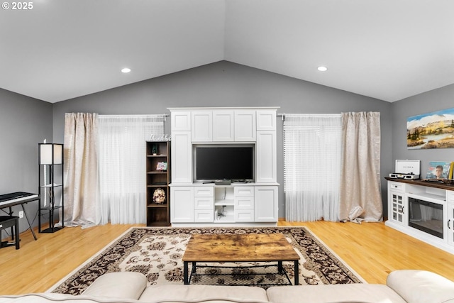 living room with light wood-type flooring and lofted ceiling