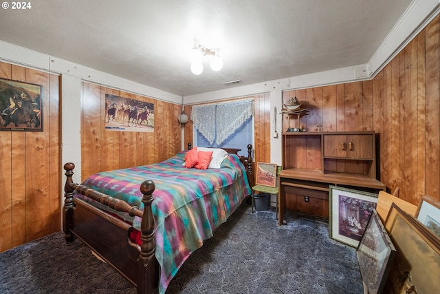 bedroom featuring wood walls and dark colored carpet