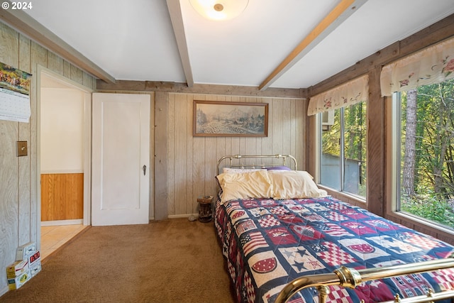 bedroom featuring wood walls, carpet floors, and beam ceiling