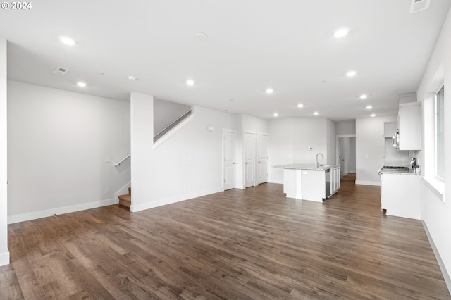 unfurnished living room with dark hardwood / wood-style flooring and sink