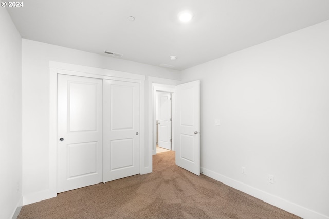 unfurnished bedroom featuring carpet and a closet