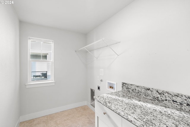 washroom featuring hookup for an electric dryer, hookup for a washing machine, light tile patterned floors, and cabinets