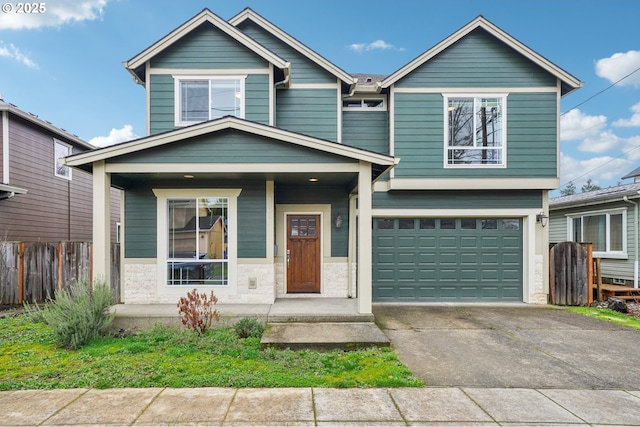 view of front of house featuring a garage, stone siding, concrete driveway, and fence