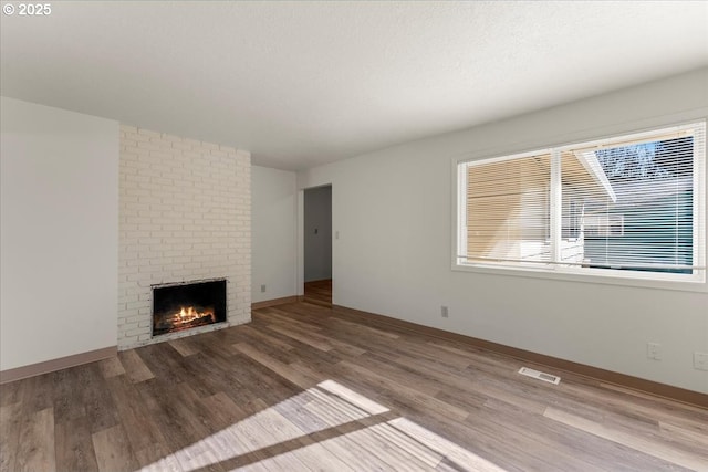 18765 SW Kinnaman Rd, Beaverton, OR 97078 - unfurnished living room with a brick fireplace, wood finished floors, and baseboards