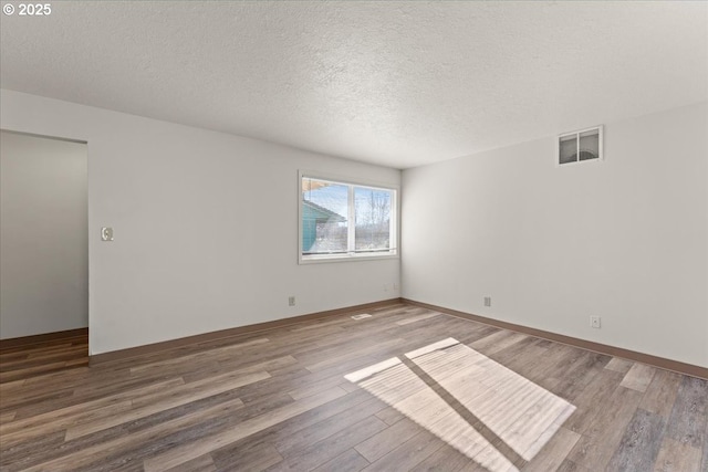 18765 SW Kinnaman Rd, Beaverton, OR 97078 - spare room with wood finished floors, a textured ceiling, and baseboards
