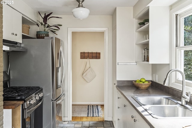 kitchen featuring open shelves, white cabinets, stainless steel range with gas stovetop, a sink, and under cabinet range hood