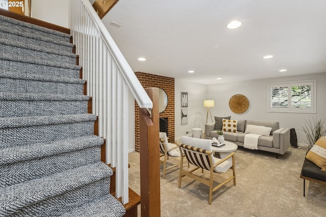 stairway featuring a brick fireplace, carpet, and recessed lighting