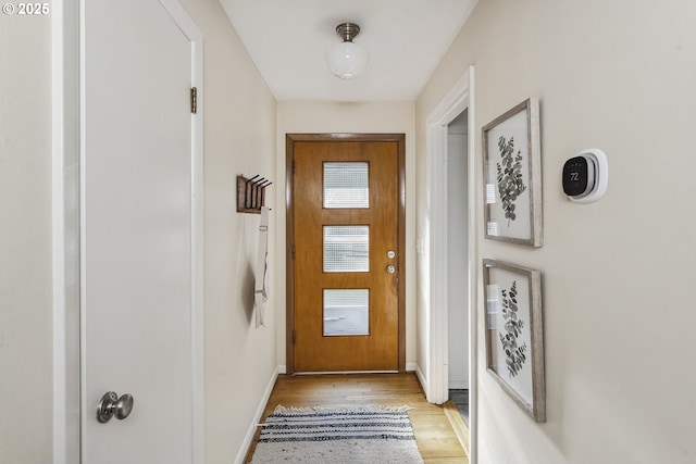 doorway to outside featuring light wood-type flooring and baseboards