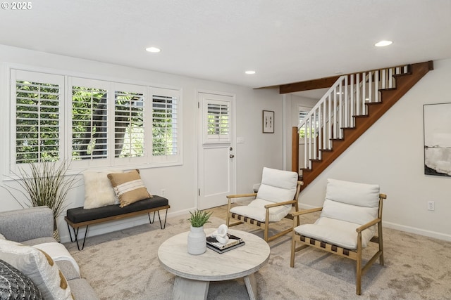 sitting room featuring light carpet, stairs, baseboards, and recessed lighting