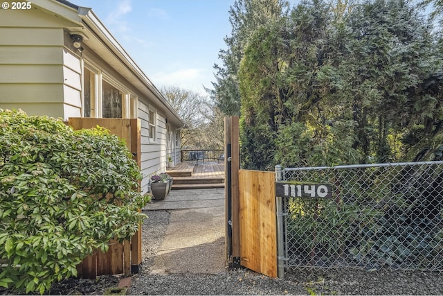 view of gate with fence and a wooden deck