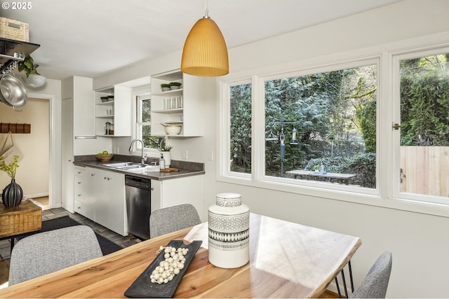 kitchen with dark countertops, a sink, white cabinetry, open shelves, and stainless steel dishwasher