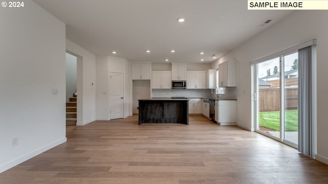 kitchen featuring dishwasher, a healthy amount of sunlight, stainless steel microwave, and decorative backsplash