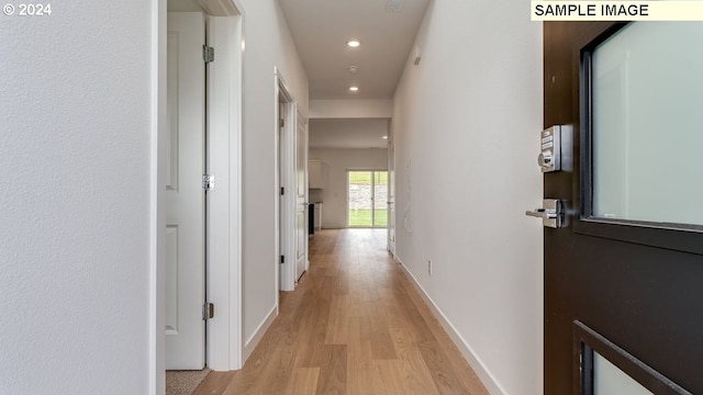 hall with light wood-type flooring, baseboards, and recessed lighting