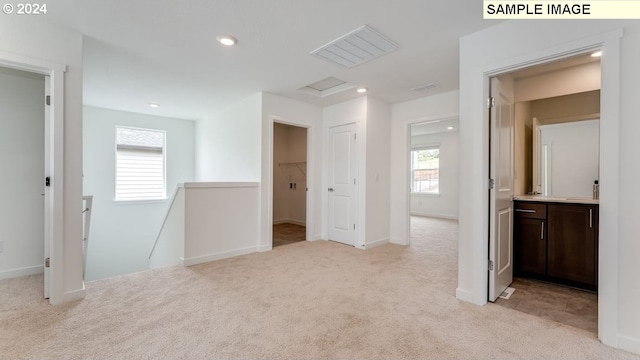 interior space with visible vents, recessed lighting, attic access, and light colored carpet