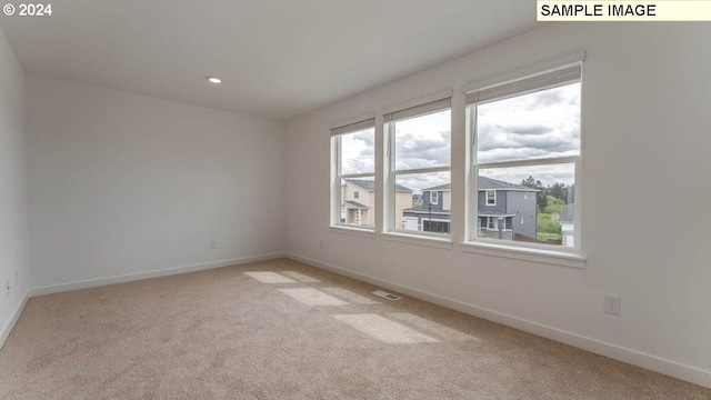 unfurnished room with light carpet, visible vents, baseboards, and recessed lighting