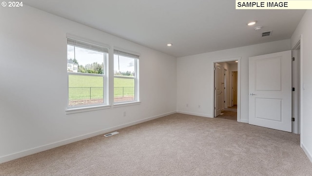 carpeted spare room featuring recessed lighting, visible vents, and baseboards