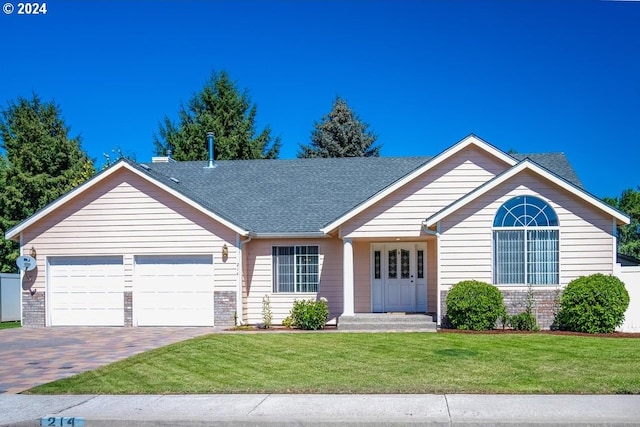 ranch-style home featuring a garage and a front lawn