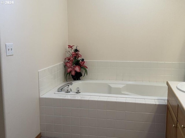 bathroom featuring vanity and tiled bath