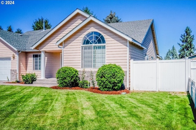 view of front of home with a front lawn and a garage