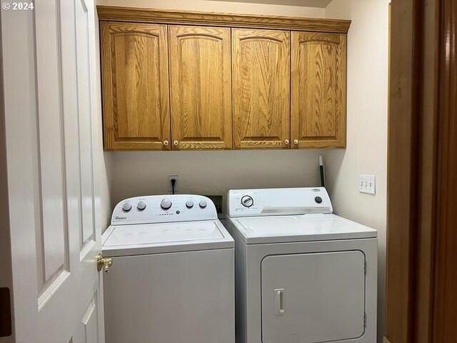 laundry room featuring cabinets and washing machine and dryer