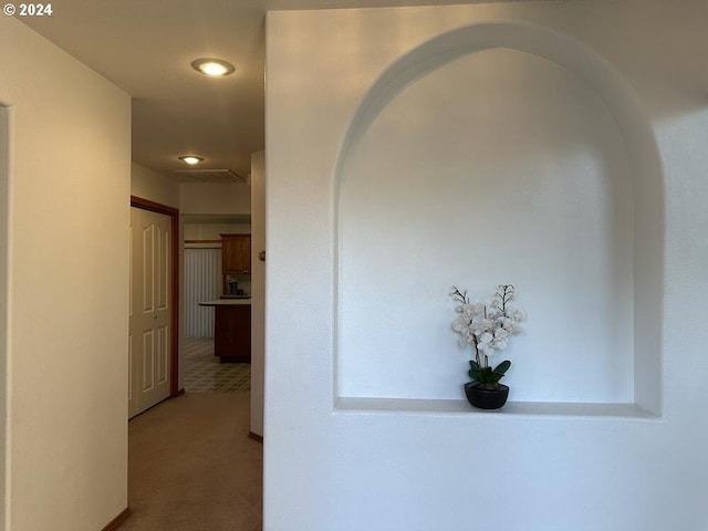 corridor with carpet floors and arched walkways