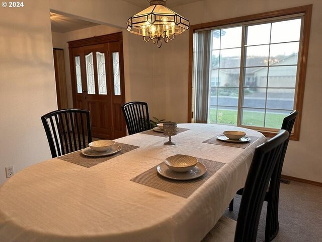 dining room featuring carpet and an inviting chandelier