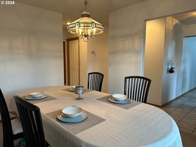 tiled dining area with a chandelier