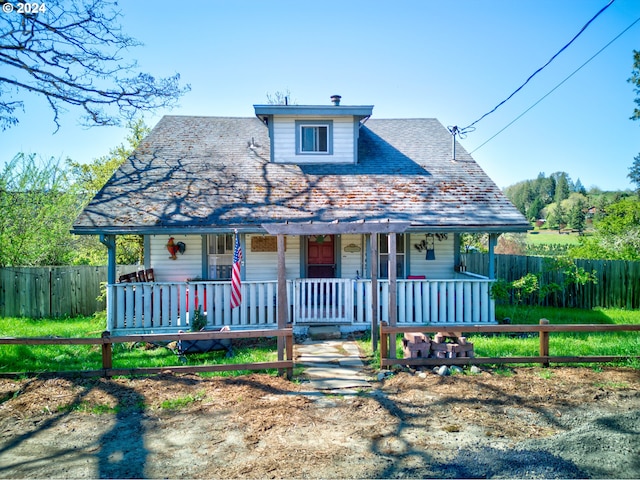 view of front of house with covered porch and fence