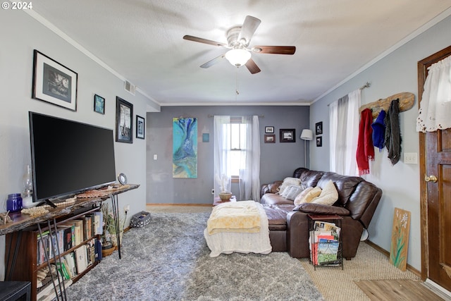 carpeted living room with ceiling fan and ornamental molding