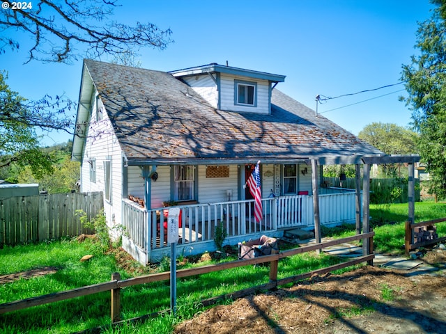 bungalow-style house featuring roof with shingles, covered porch, and fence private yard