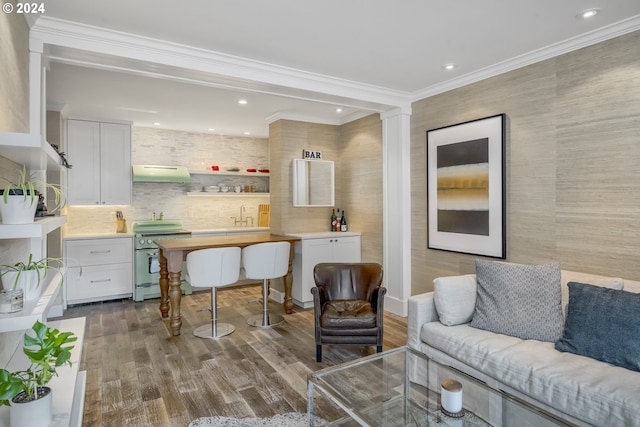 bar with white cabinetry, white range oven, crown molding, hardwood / wood-style floors, and extractor fan