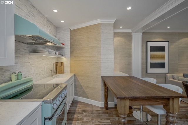 kitchen featuring stainless steel range with electric cooktop, dark wood-type flooring, white cabinets, sink, and wall chimney exhaust hood