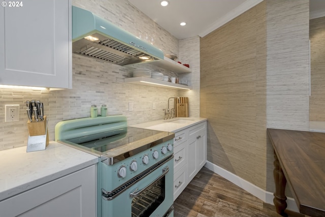 kitchen with dark hardwood / wood-style flooring, wall chimney exhaust hood, sink, electric stove, and white cabinetry