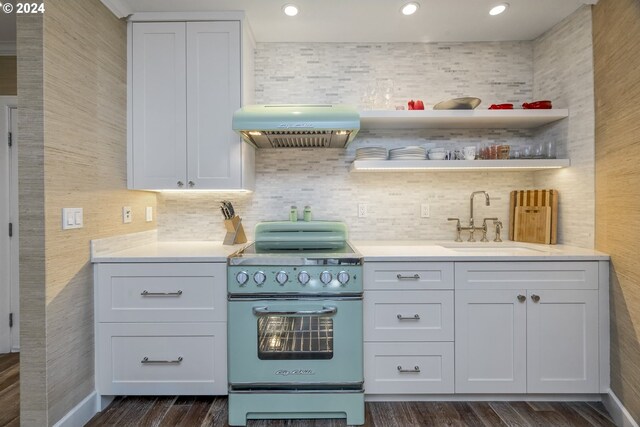 kitchen with range, ventilation hood, white cabinetry, and sink