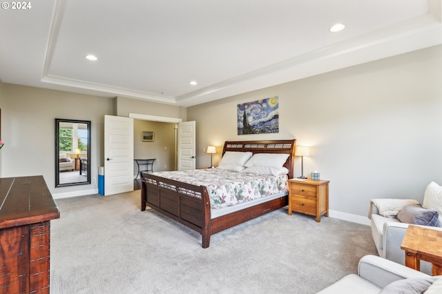 carpeted bedroom with a raised ceiling