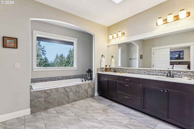 bathroom with vanity and a relaxing tiled tub