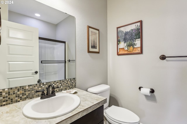 bathroom featuring vanity, backsplash, and toilet