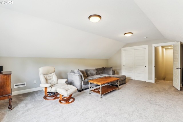 sitting room with carpet floors and vaulted ceiling