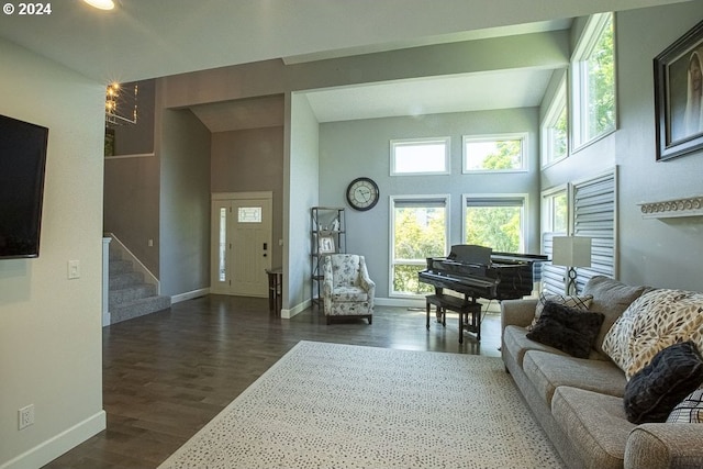 living room with a towering ceiling and dark hardwood / wood-style floors