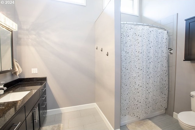 bathroom with vanity, curtained shower, and toilet