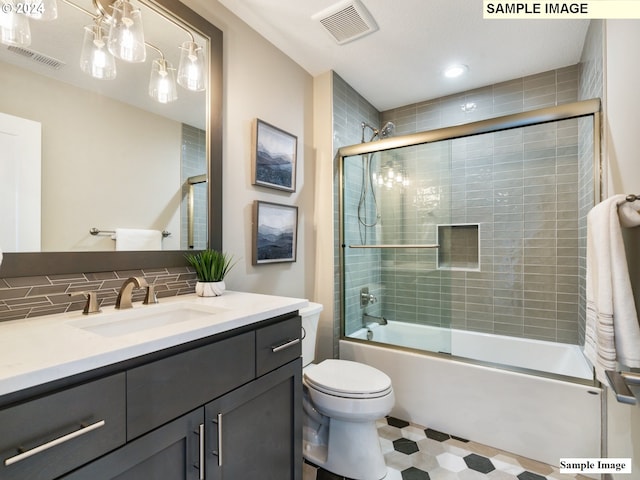 full bathroom featuring tasteful backsplash, vanity, bath / shower combo with glass door, and toilet