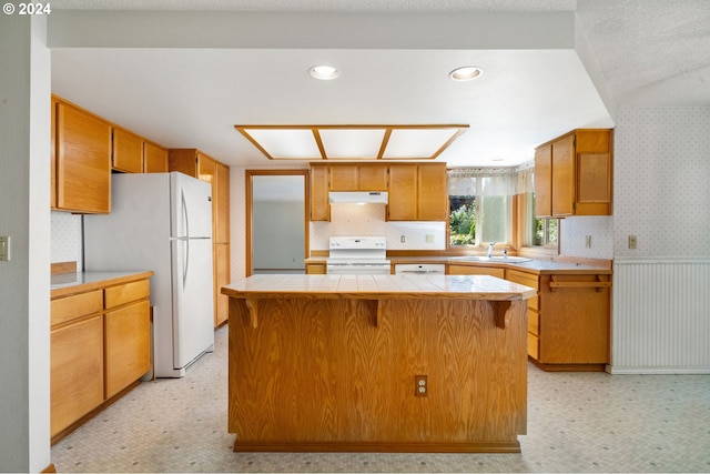 kitchen featuring sink, tile counters, white appliances, and light tile patterned floors