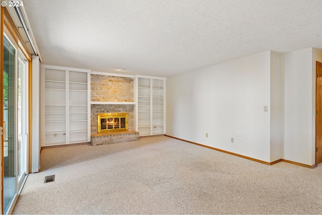 unfurnished living room with a textured ceiling, built in features, brick wall, a fireplace, and light carpet