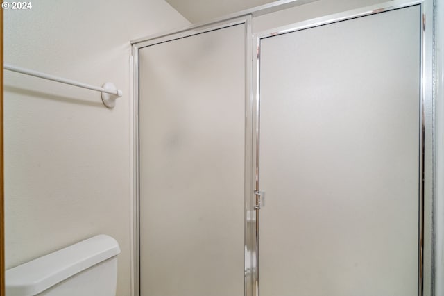 bathroom featuring walk in shower and toilet