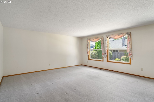 carpeted spare room featuring a textured ceiling