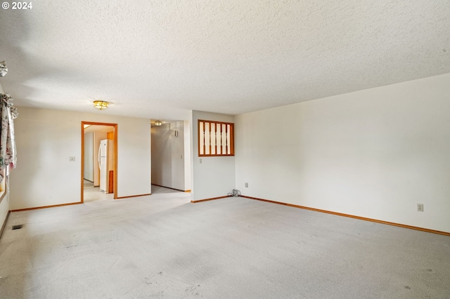 carpeted empty room featuring a textured ceiling